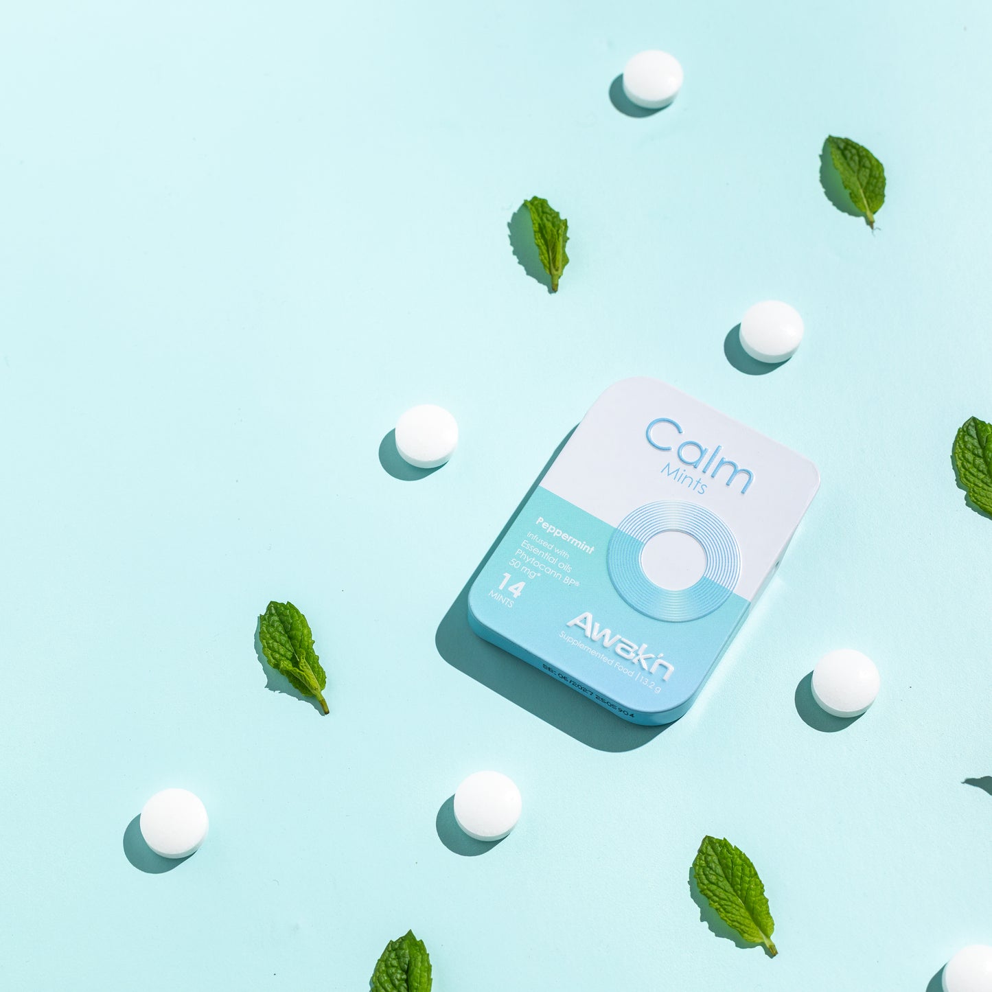 Calm tin with mint leaves and white capsules on a light blue background